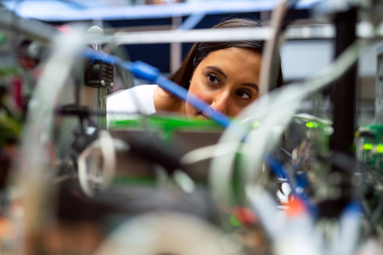 Home Focused female engineer analyzing equipment at a modern lab.